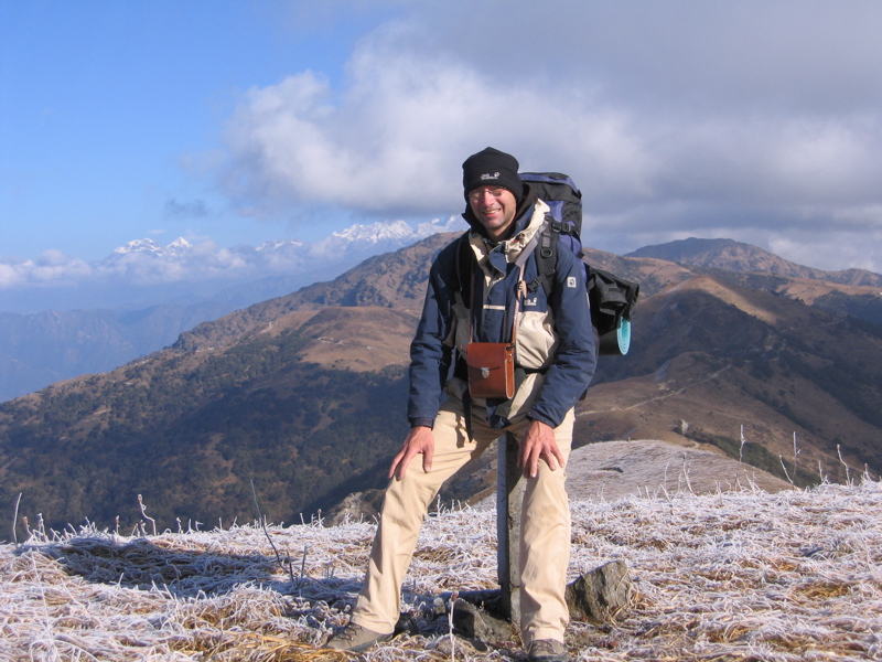 The author sitting on the border of Nepal (left) and India (right); the nearest mountain in the background is Phalut